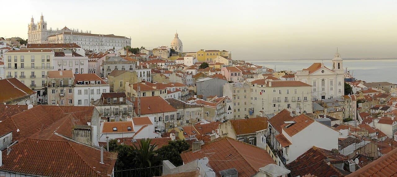 A narrow cobbled street with tiled buildings in the Alfama district, Lisbon